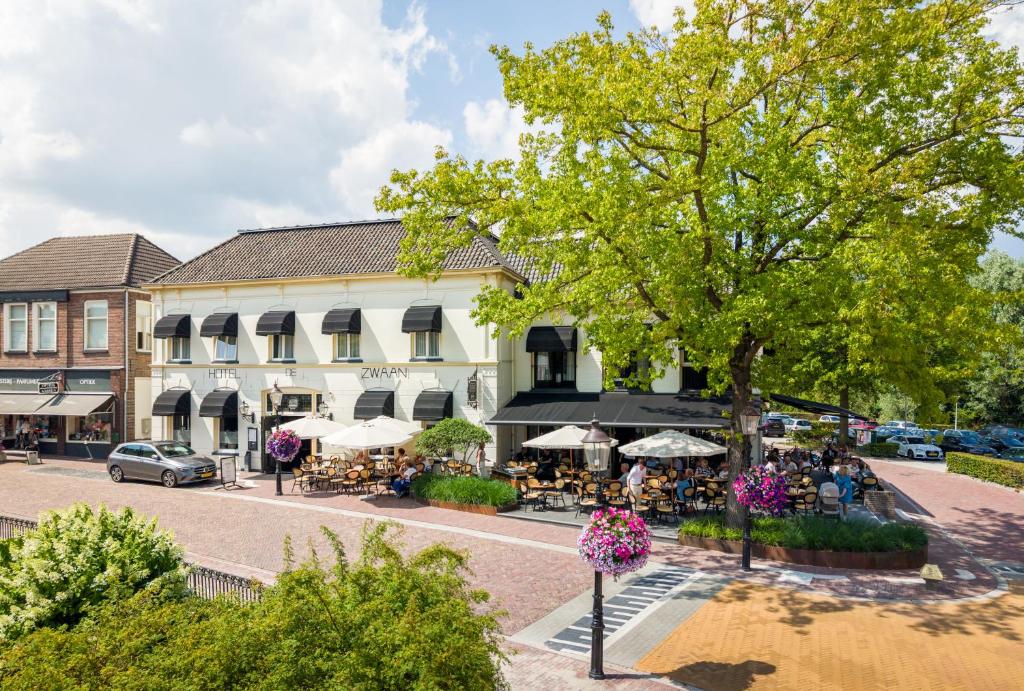 a street in a town with a building at De Zwaan Delden in Delden