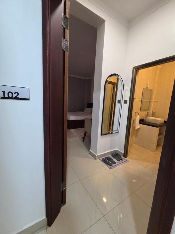a room with a mirror and a bathroom at Paramount Boutique Hotel in Entebbe