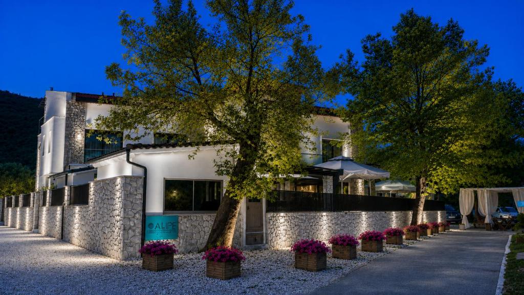 a building with potted plants in front of it at ALPE LUXURY ACCOMMODATION Penelope Collection in Olympiada