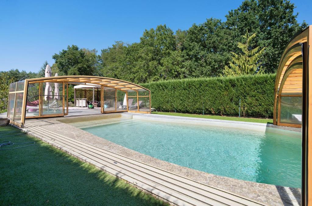 a swimming pool with a gazebo and a house at La Table De Pierre - Chambre d'Hôte in Lussas-et-Nontronneau