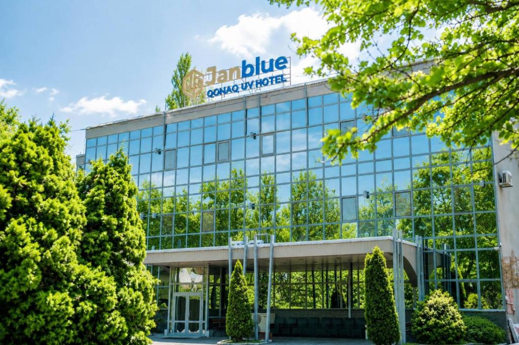 an office building with a sign on top at Janblue Hotel in Almaty