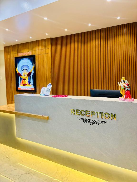 a reception desk in a lobby with a reputation sign at HariPriya Executive in Tuljapur