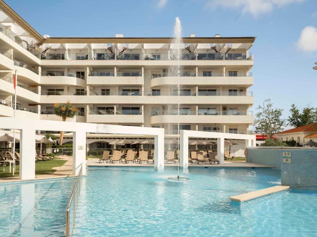 a swimming pool in front of a large building at Ona Garden Lago in Port d'Alcudia