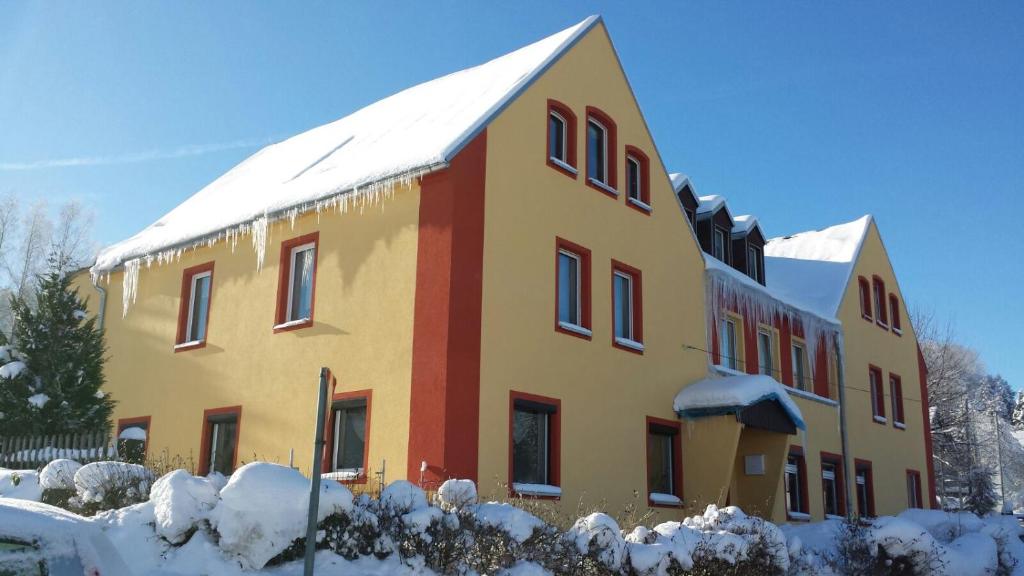a large building with snow on the roof at Schullandheim Sohland Spree in Auf der Wiese