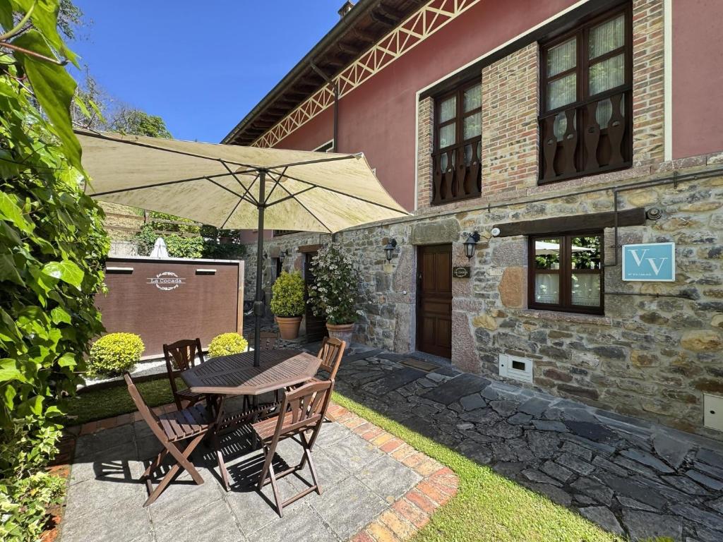 a patio with a table and chairs and an umbrella at Vivienda Vacacional La Cocada VV-144-AS in Arriondas