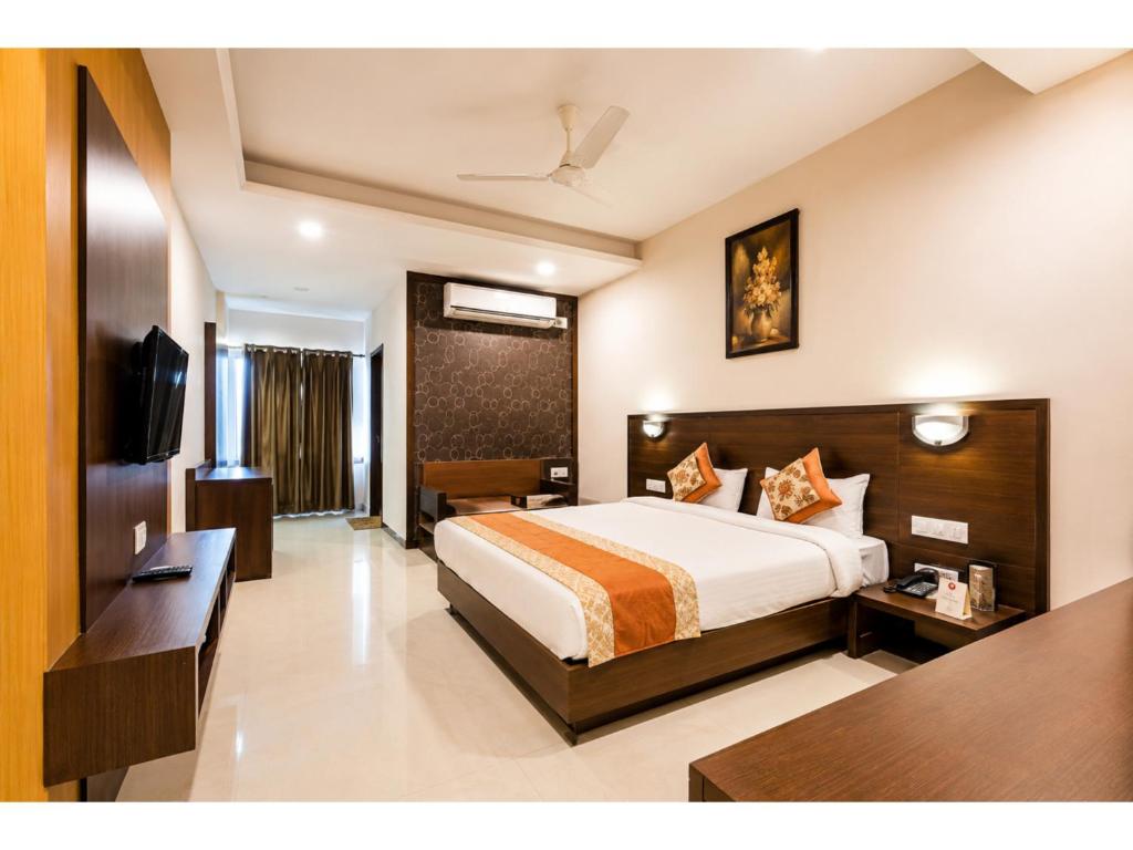 a hotel room with a bed and a television at Hotel Park Premium With Restaurant & Banquet Ujjain - By D S Stay Group in Ujjain