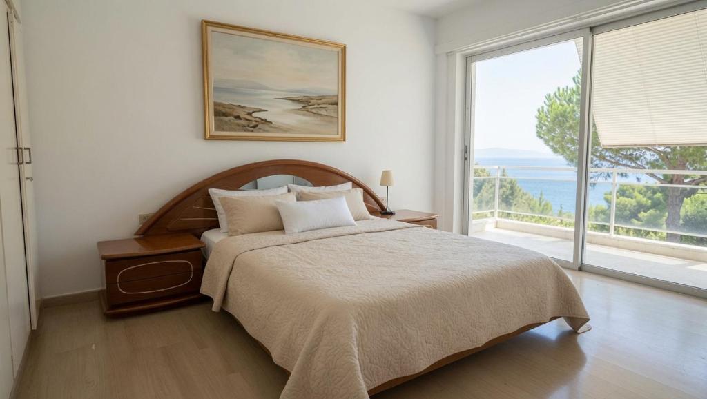 a bedroom with a bed and a large window at Kineta Prime Suites No1 in Kineta