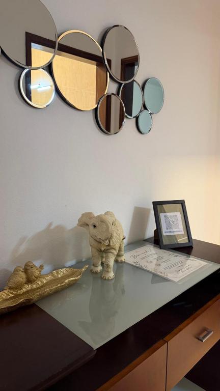 a stuffed elephant sitting on a desk with a group of mirrors at Casa da Margarida in Castro Marim