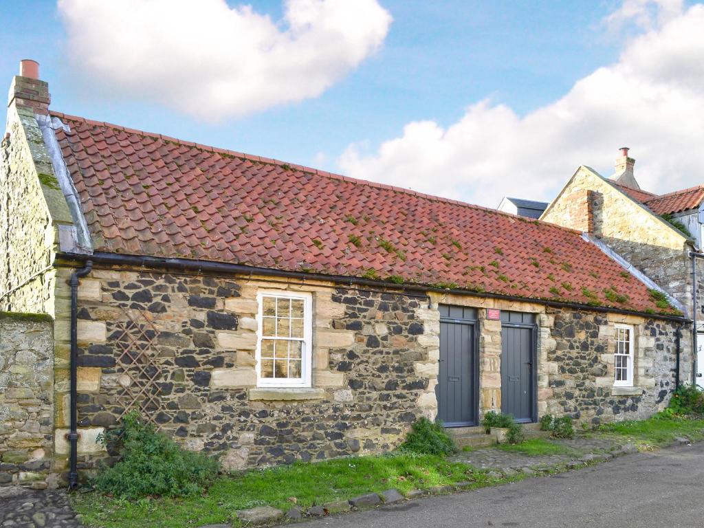 an old stone house with a red roof at Lee Cottage - E4343A in Holy Island