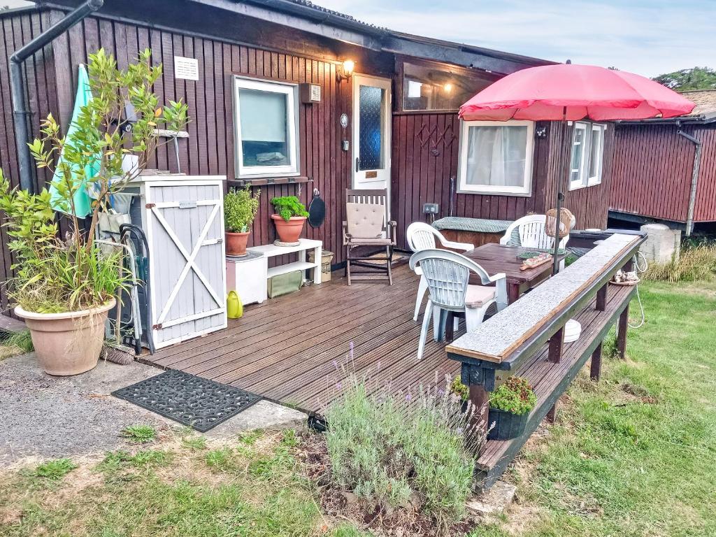 a wooden deck with a table and an umbrella at 28 Awelon in Cenarth