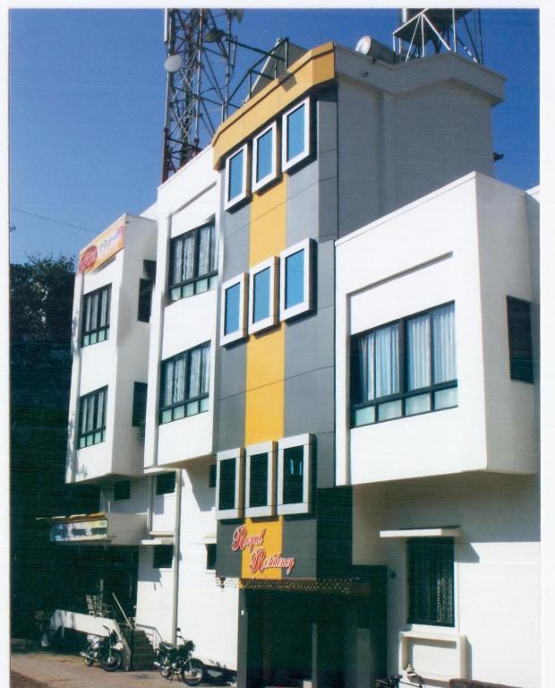 a tall white building with a sign on it at Hotel Royal Residency Executive in Miraj