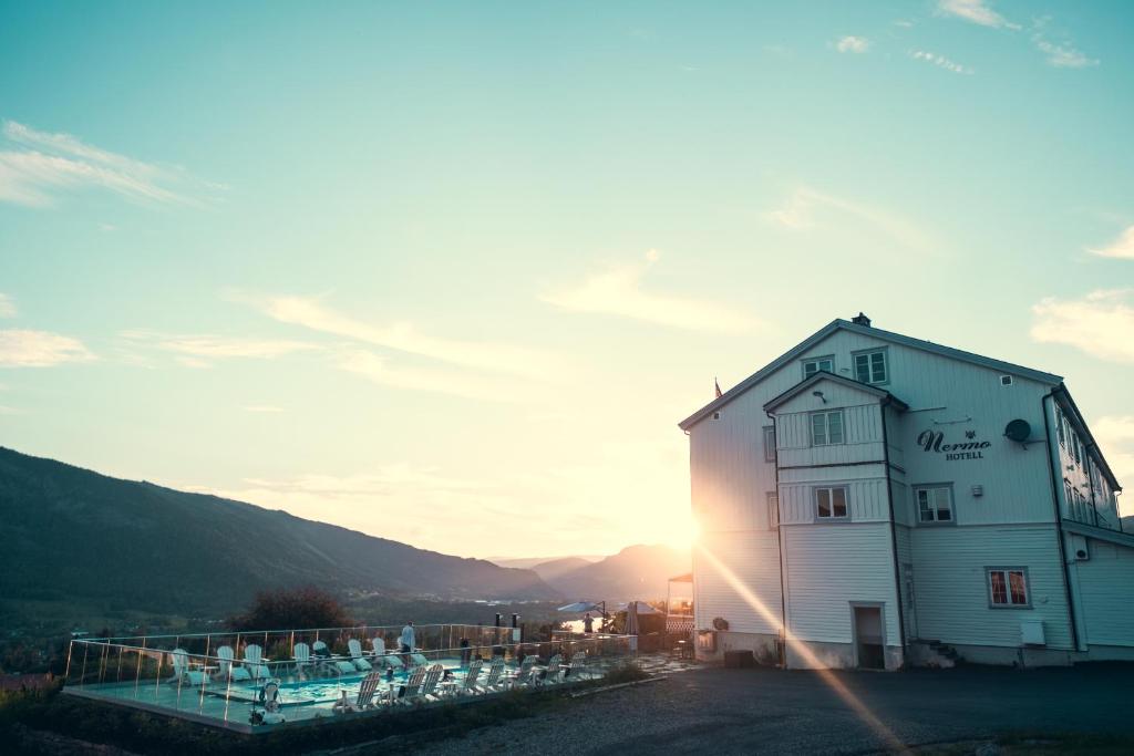 ein großes weißes Gebäude mit Stühlen davor in der Unterkunft Nermo Hotel & Apartments in Hafjell