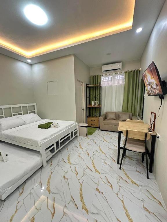 a bedroom with a bed and a desk and a couch at Green Meadows Residence Naga in Milaor