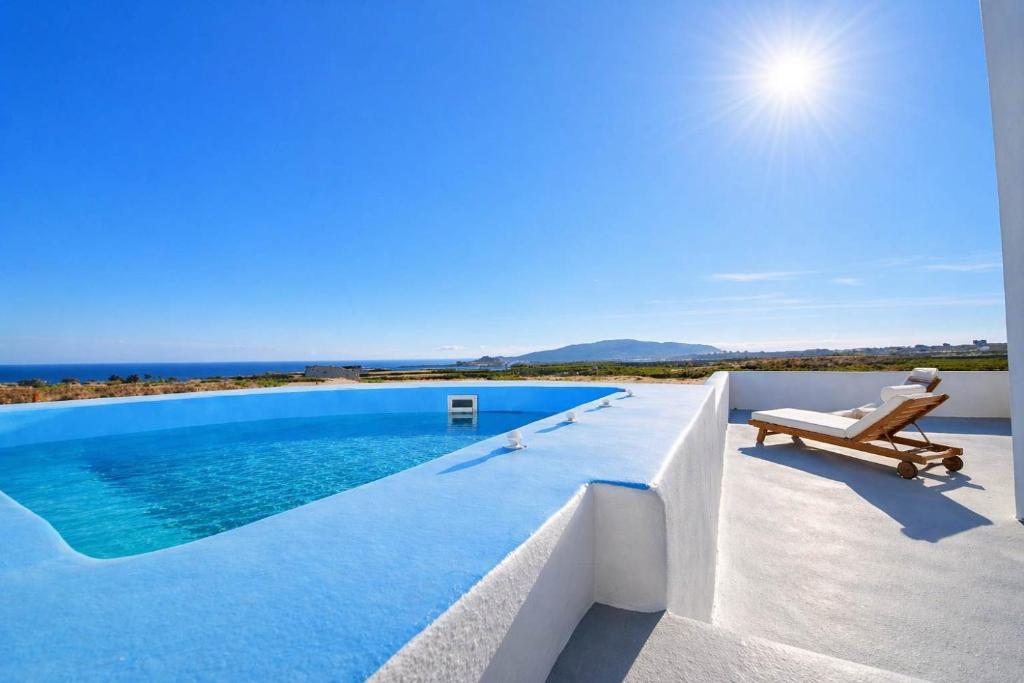 a villa with a swimming pool and a chair at Villa Therme Athen - Sea View Jacuzzi Santorini Stay in Emporio