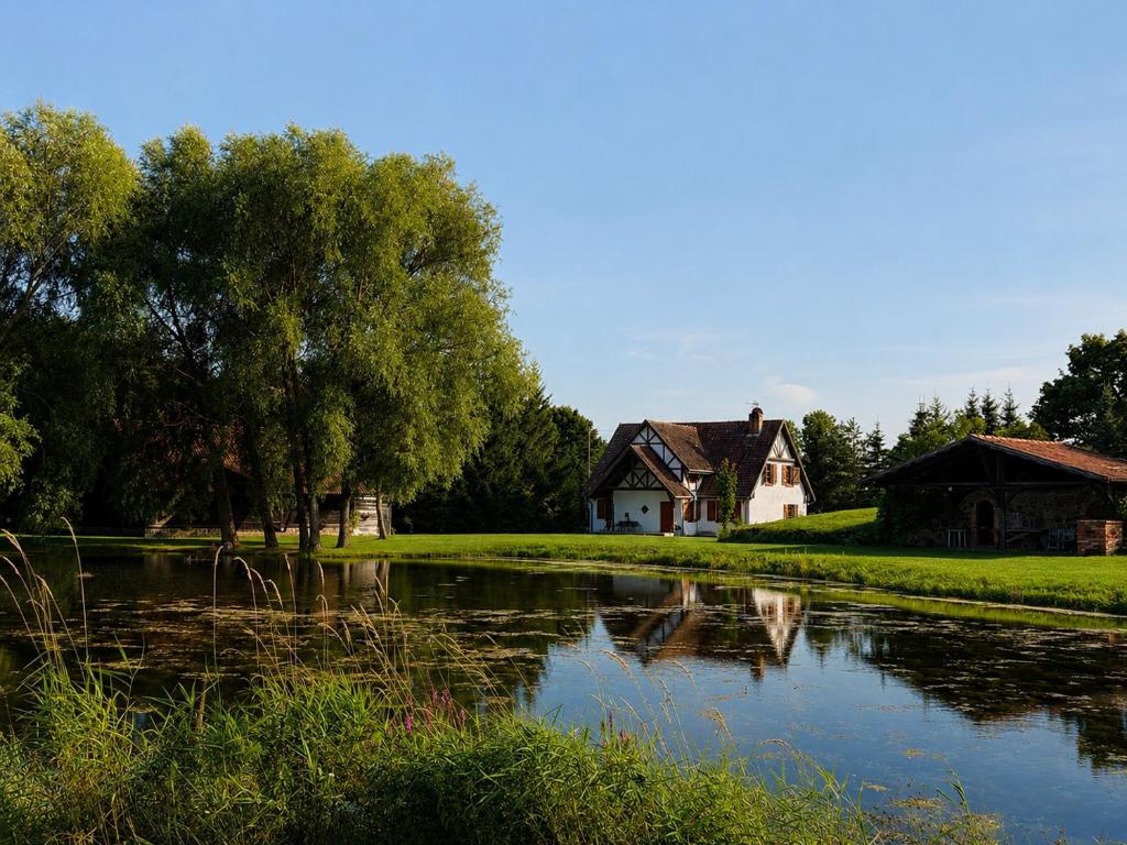 a house next to a pond with a house at Siedlisko Mieruniszki in Mieruniszki