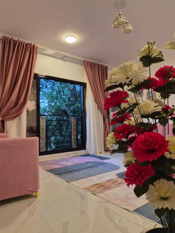a room with a table with red and white flowers at Thebes Guest house in Jazīrat al ‘Awwāmīyah