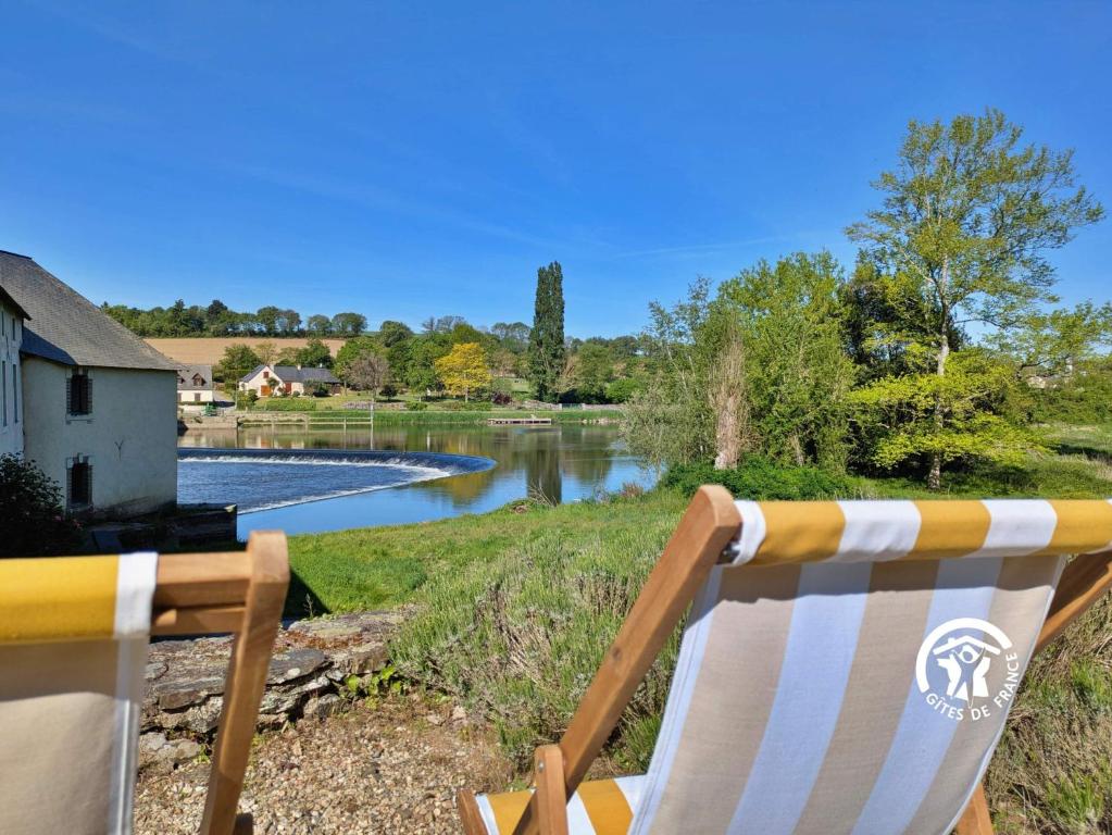 a rocking chair sitting next to a body of water at La Roche des Eaux Vives, 2 personnes in Fromentières