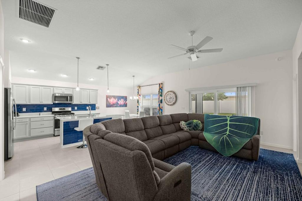 a living room with a couch and a kitchen at Spacious 3BR - Sleeps 7 - King Bed - Lanai in Okahumpka