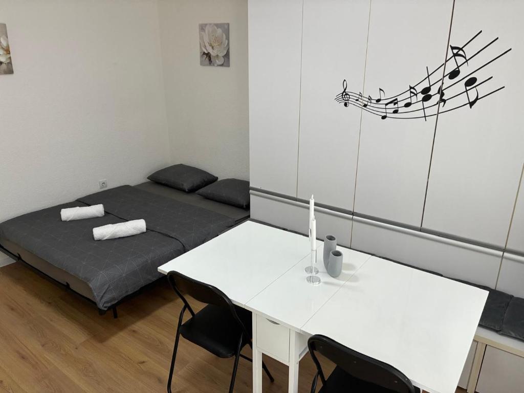 a small room with a bed and a white table at Apartment S&S Tomislavgrad in Tomislavgrad