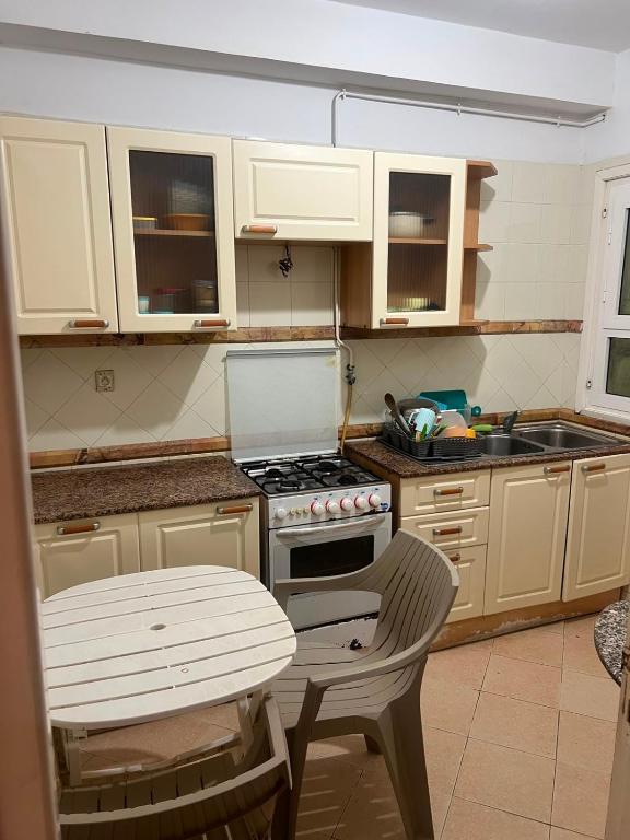 a kitchen with a stove and a sink and a table at Dar El vague in Hiboun