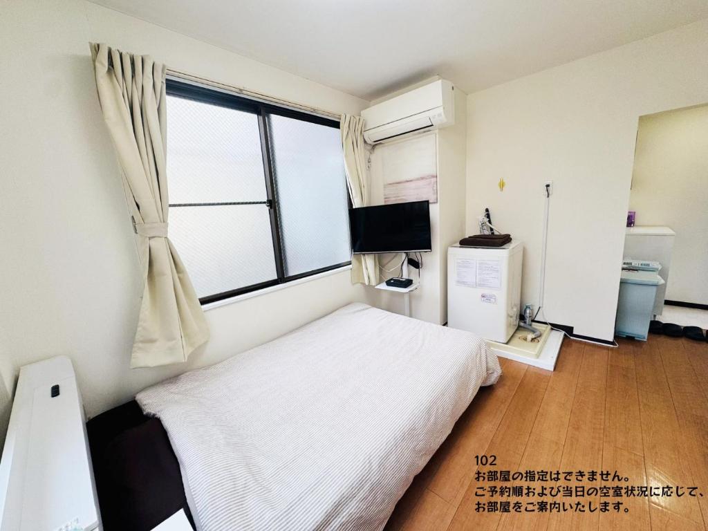 a bedroom with a white bed and a window at SnowMapleHouse川口 in Kawaguchi
