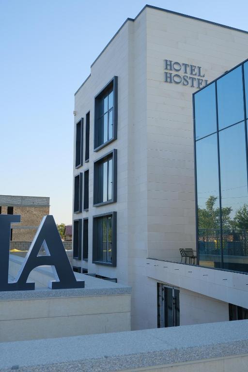 a hotel with a sign on the side of a building at GAIA Hostel in Türkistan