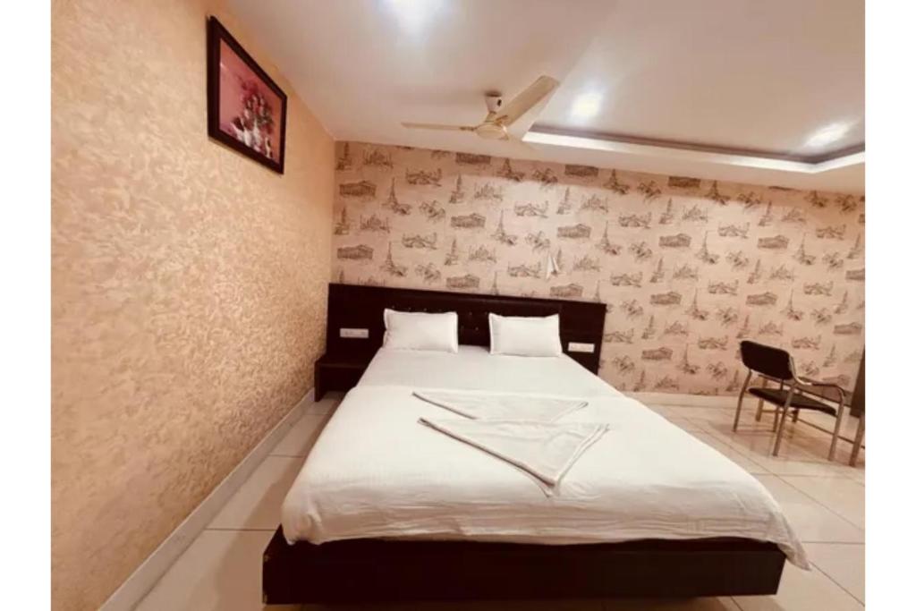 a bedroom with a bed with a white blanket at FabHotel Udupi in Mysore