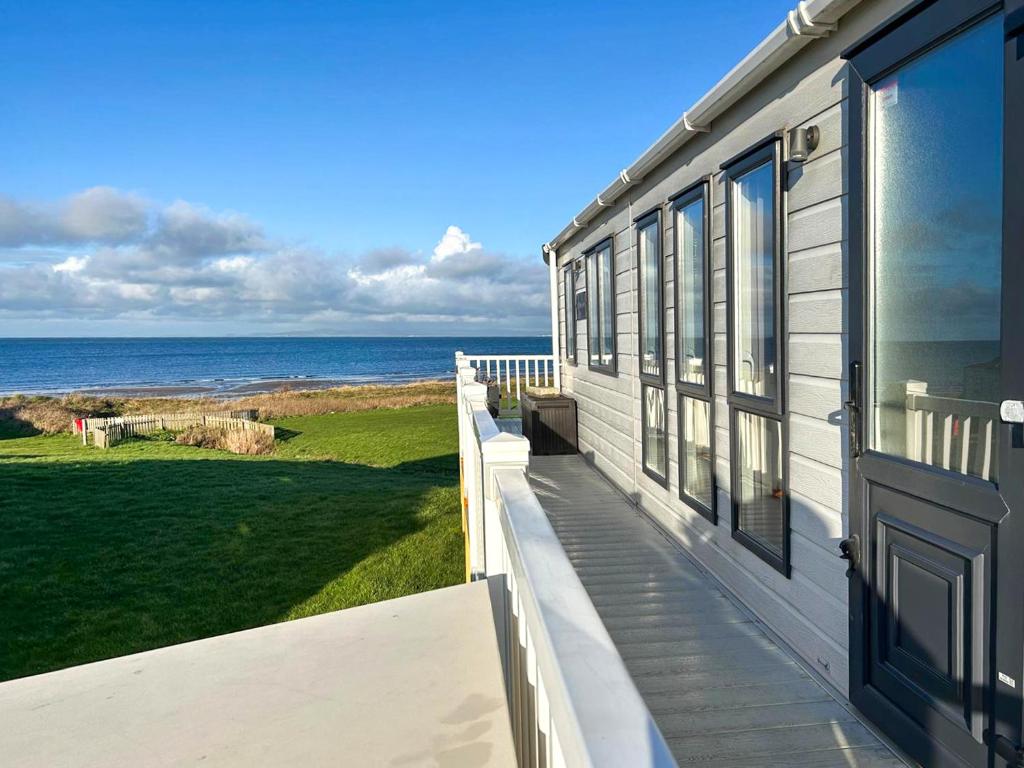 a house with a balcony looking out at the ocean at Millars Caravan in Ayr