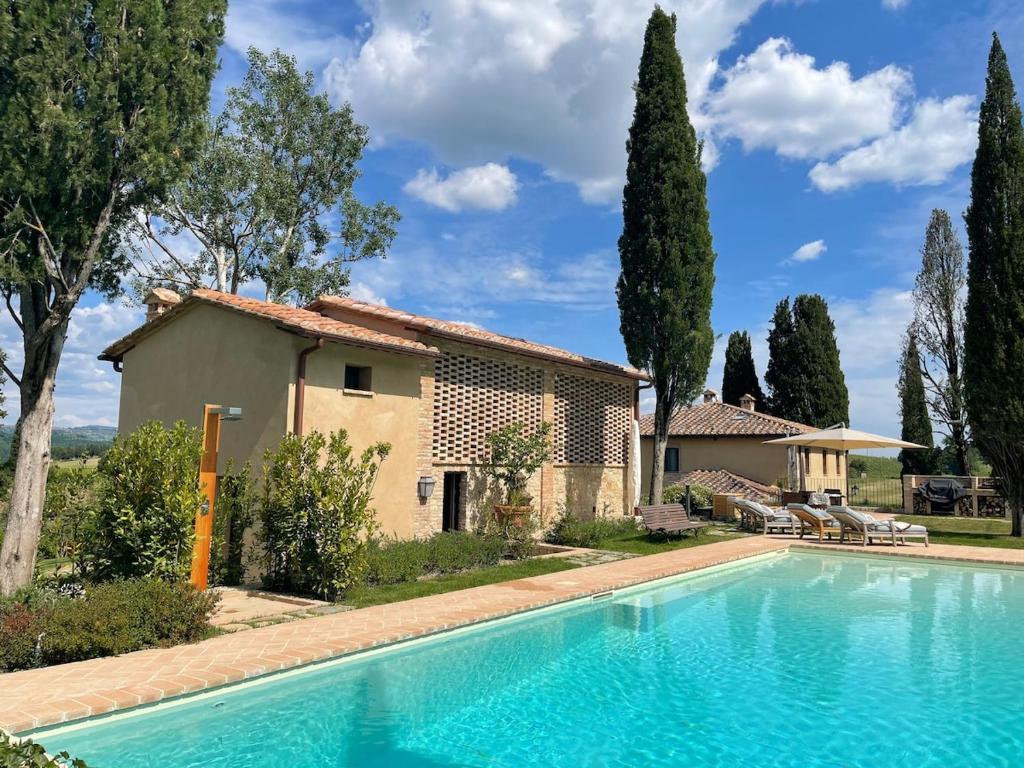 a villa with a swimming pool in front of a house at Podere San Pietro in Cetona