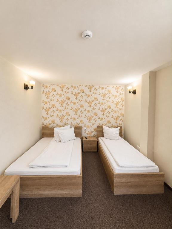 two beds in a small room withermottermottermott at Pensiunea Mirela Bears Cave in Chişcău