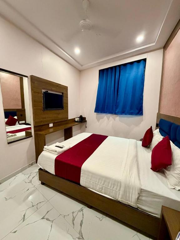 a bedroom with a large bed with a blue window at Hotel Classy Comfort Business Family Hotel in Mumbai