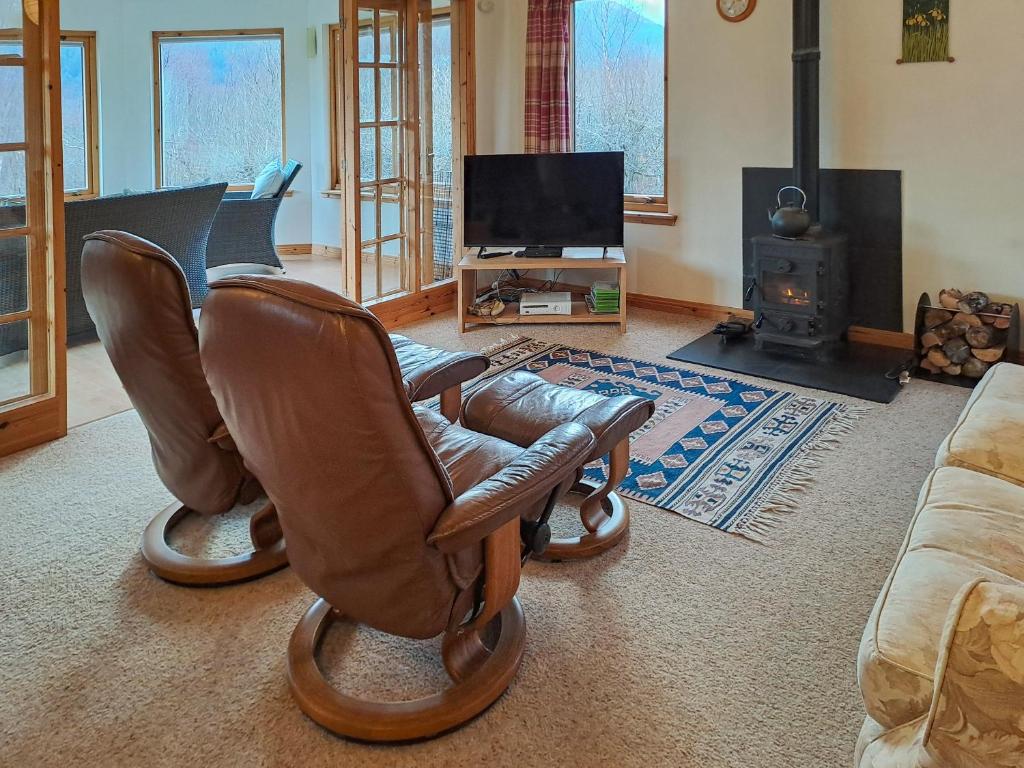a living room with two chairs and a television at Nether Carness in North Ballachulish