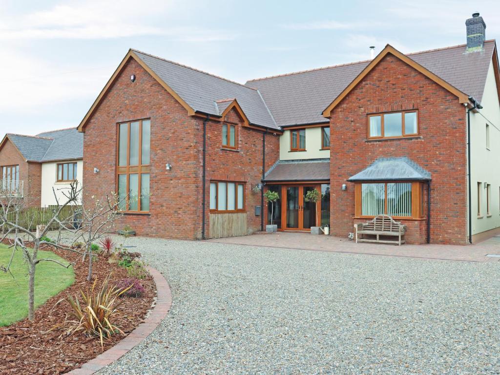 a brick house with a driveway in front of it at Cefn Y Gwynt in Llangranog