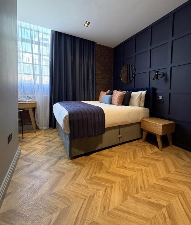 a bedroom with a large bed and a wooden floor at Hütel in Liverpool