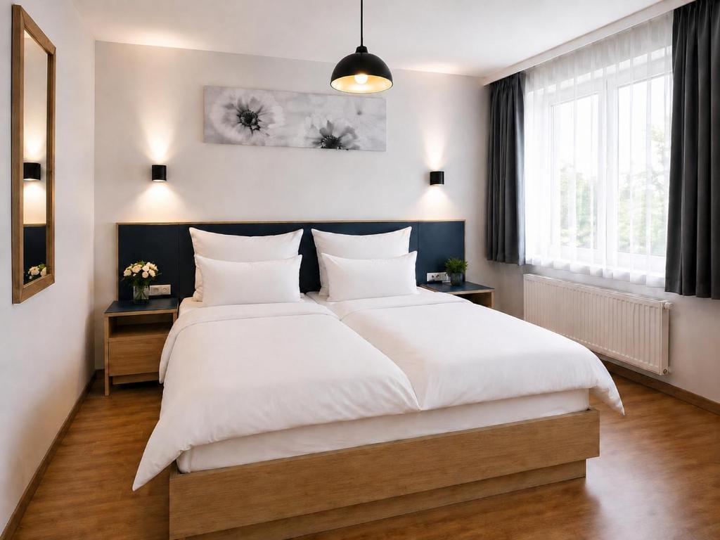 a bedroom with a large bed with white sheets at Hotel Central Nürnberg Hauptbahnhof in Nuremberg