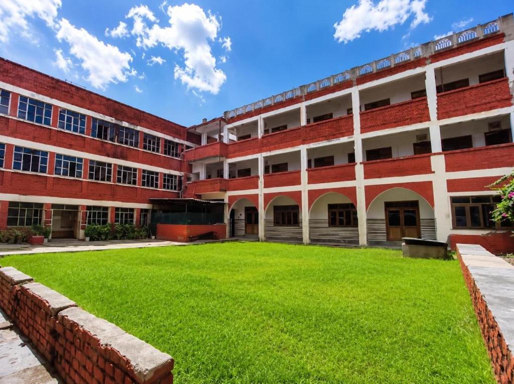 an empty school building with a lawn in front at Hotel Goverdhan - Walking to Raja Ki Mandi Railway and 3km from ISBT in Agra