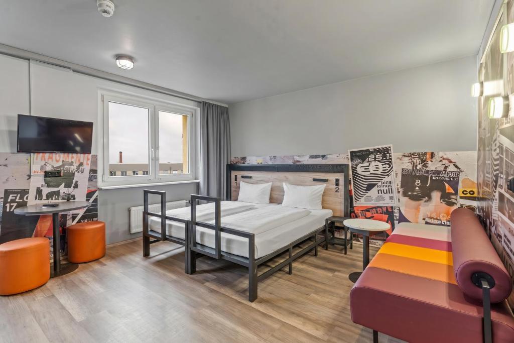 ein Schlafzimmer mit einem Bett und einer Couch in der Unterkunft a&o Berlin Mitte in Berlin