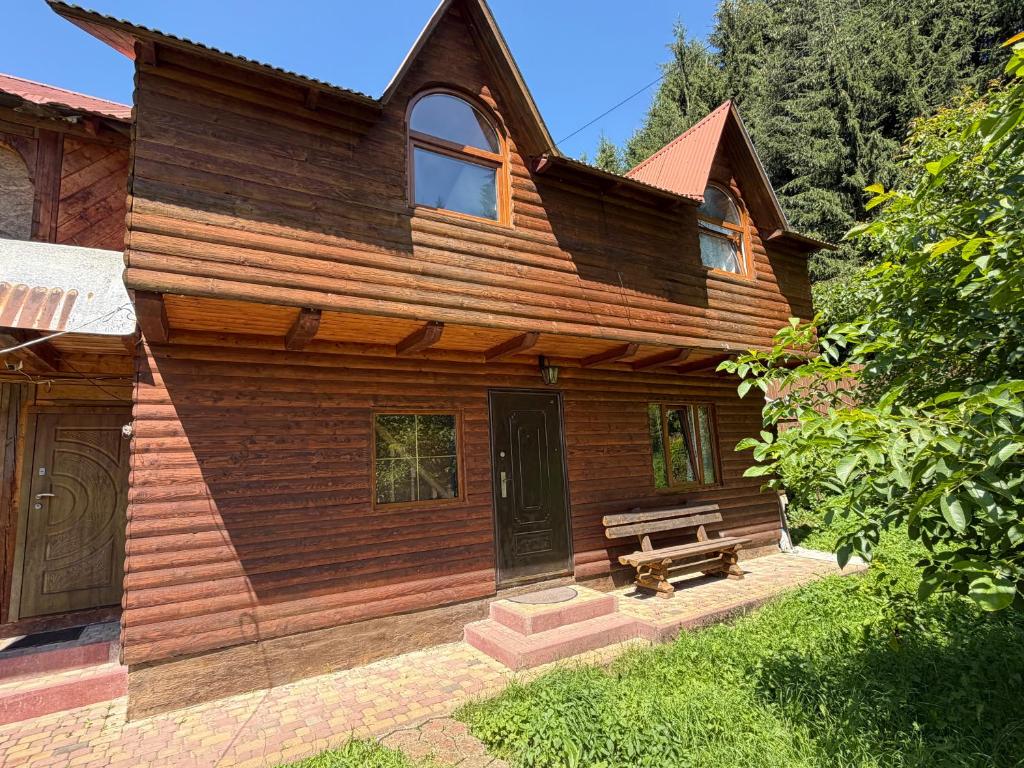 a wooden house with a bench in front of it at Shelest Vody in Russkaya Mokraya