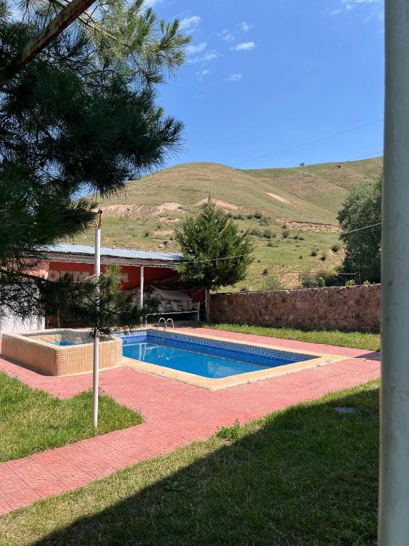a swimming pool in front of a house at Gostevoy dom Dovul in Chimgan
