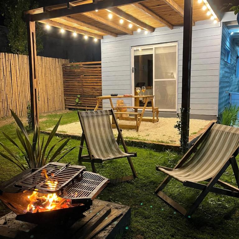 two chairs and a fire pit in a backyard at Entre Las Sierras Tiny House Cabañas in Villa Giardino