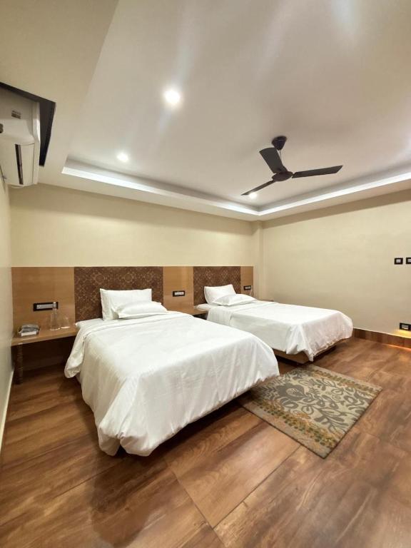a bedroom with two beds and a ceiling at Anaya Regency in Naya Bāzār