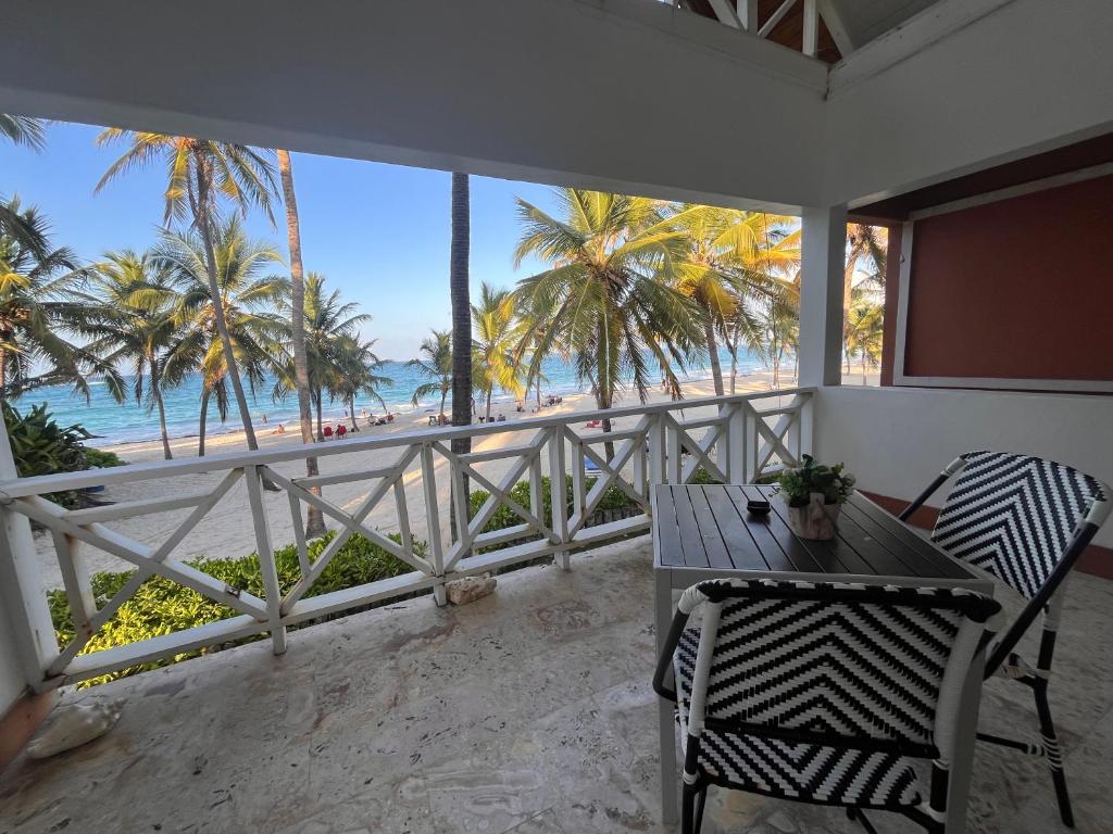 a balcony with a table and chairs and a view of the beach at Villa Arena Blanca in Punta Cana