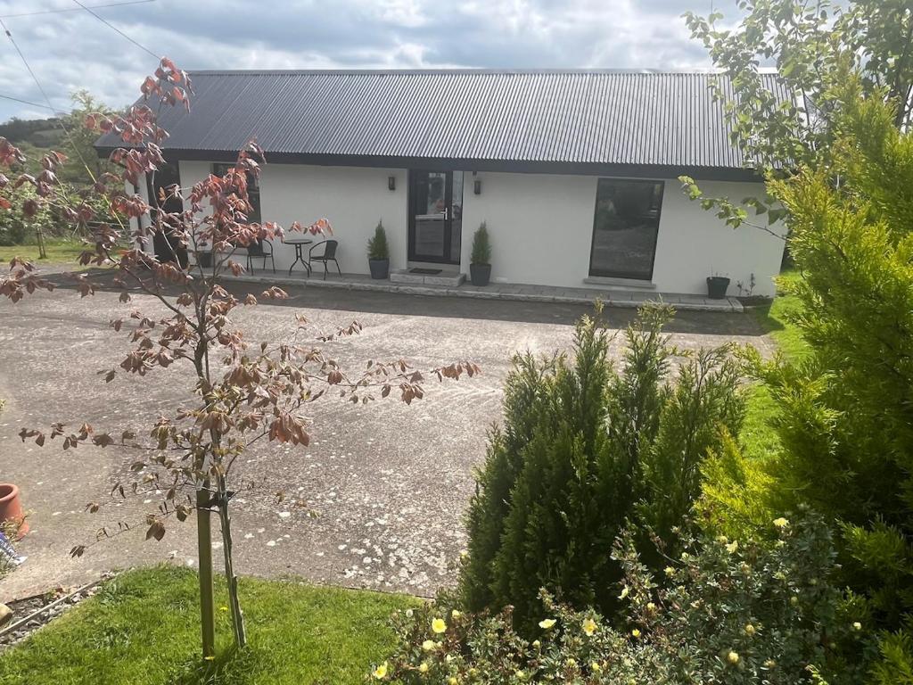 a white house with a table in front of it at Glassdrumman Stables in Ballynahinch