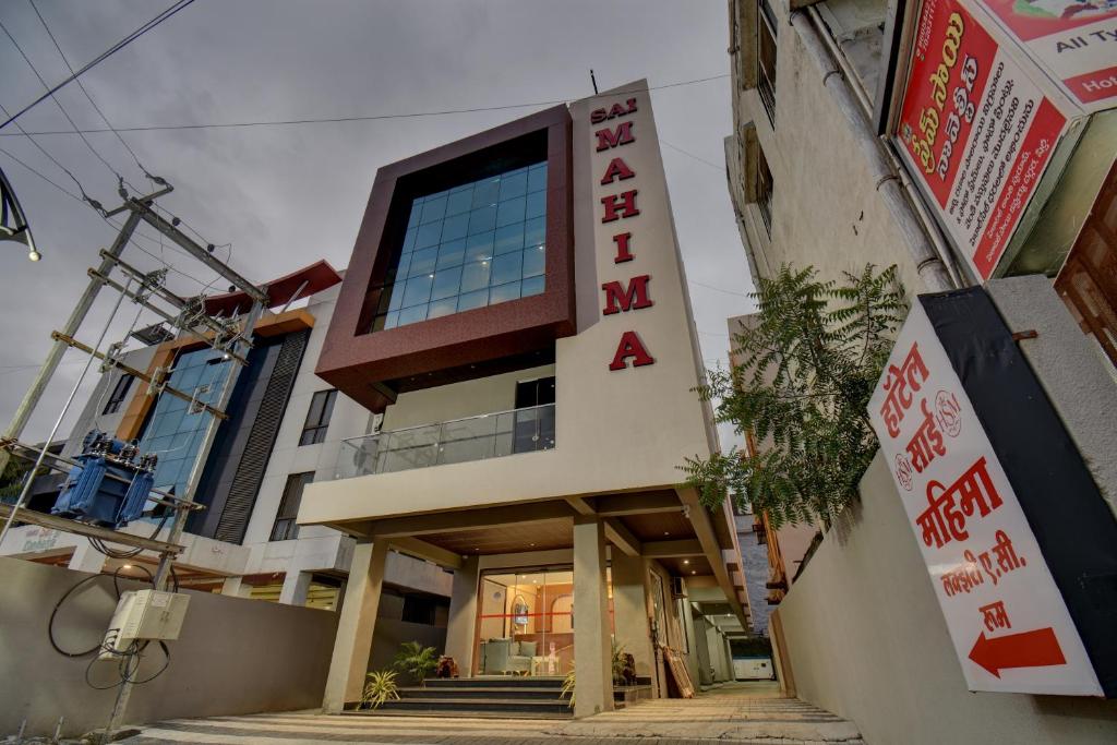 a building with a sign on the side of it at Hotel Sai Mahima, Near Sai Baba Temple in Shirdi