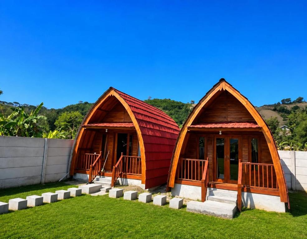 two small huts are sitting on the grass at Wavez Bungalow in Selong Belanak