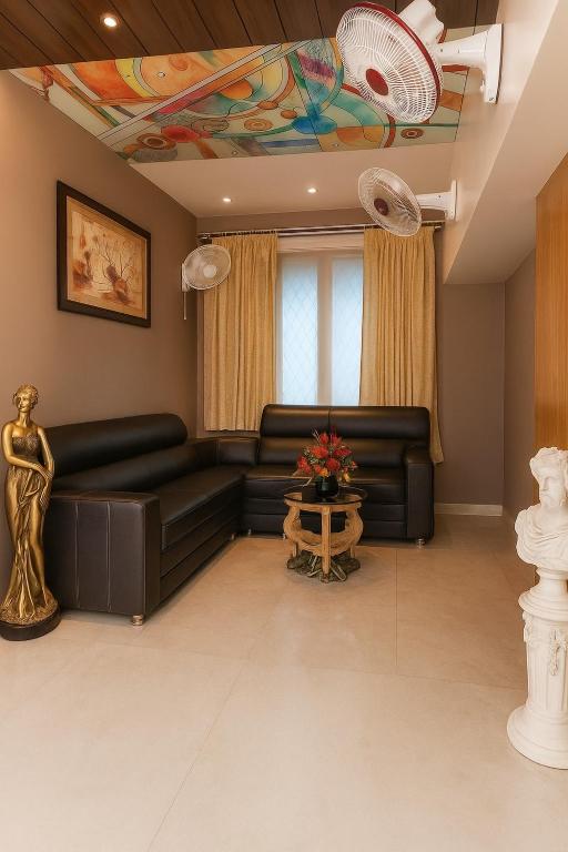 a living room with a black leather couch at Luxurious Duplex Villa in Hyderabad