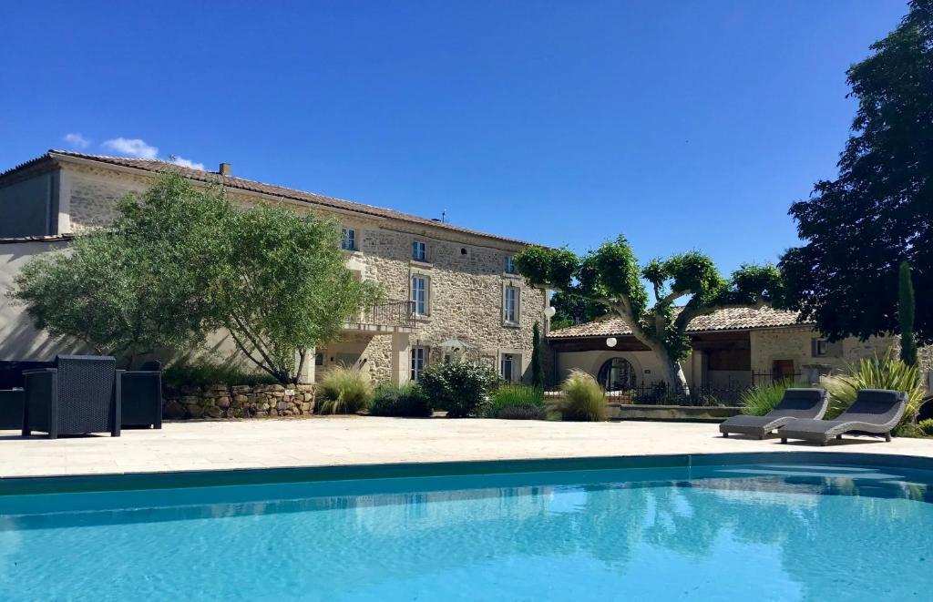 a large swimming pool in front of a house at Domaine Chamarel in Saint-Paulet-de-Caisson