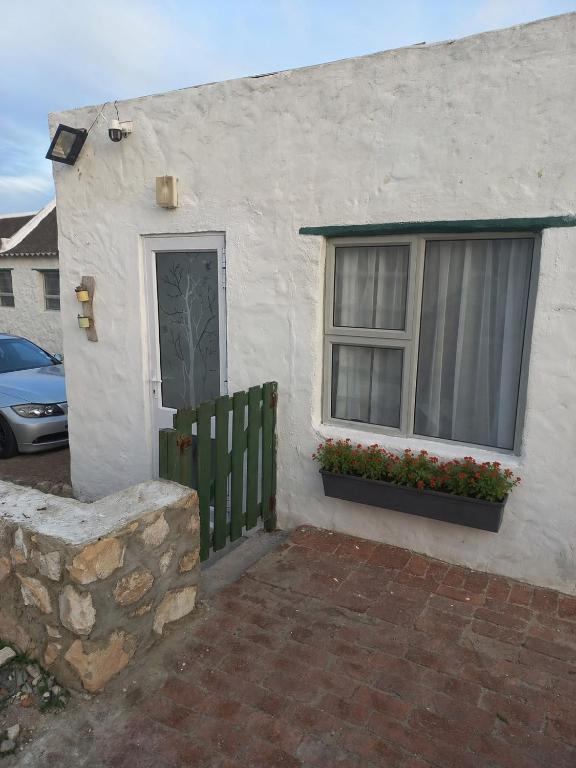 a white house with a window and a door at Die Waenhuis in Arniston