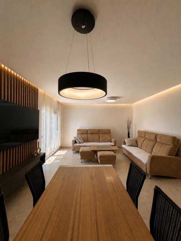 a living room with a table and a couch at Apartman Šarić in Neum