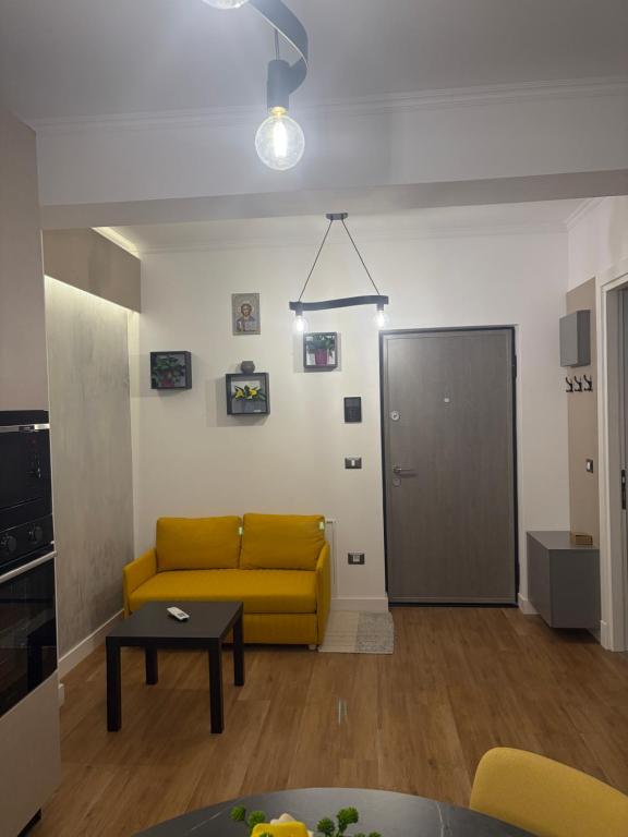 a living room with a yellow couch and a door at Lili room in Focşani